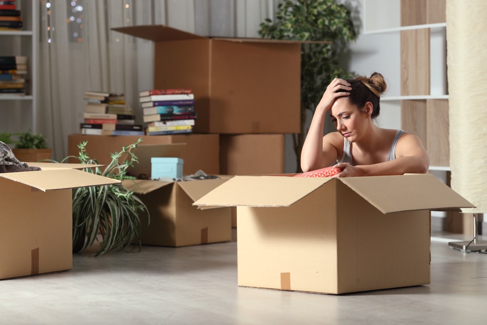 Evicted woman preparing to move surrounded by boxes