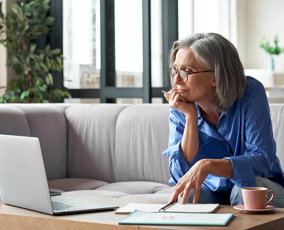 Woman looking at her laptop on couch